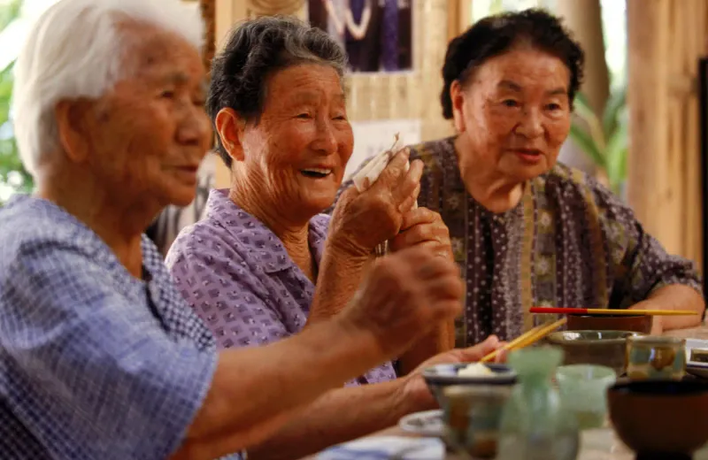 Three older Japanese women sharing a meal in Okinawa